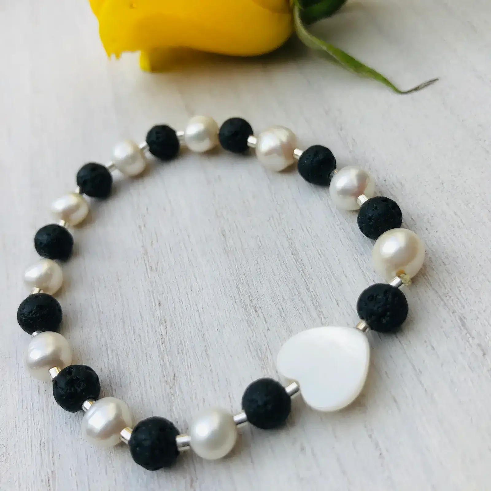 Pulsera elasticada piedras volcánicas y perlas de río con detalles de plata
