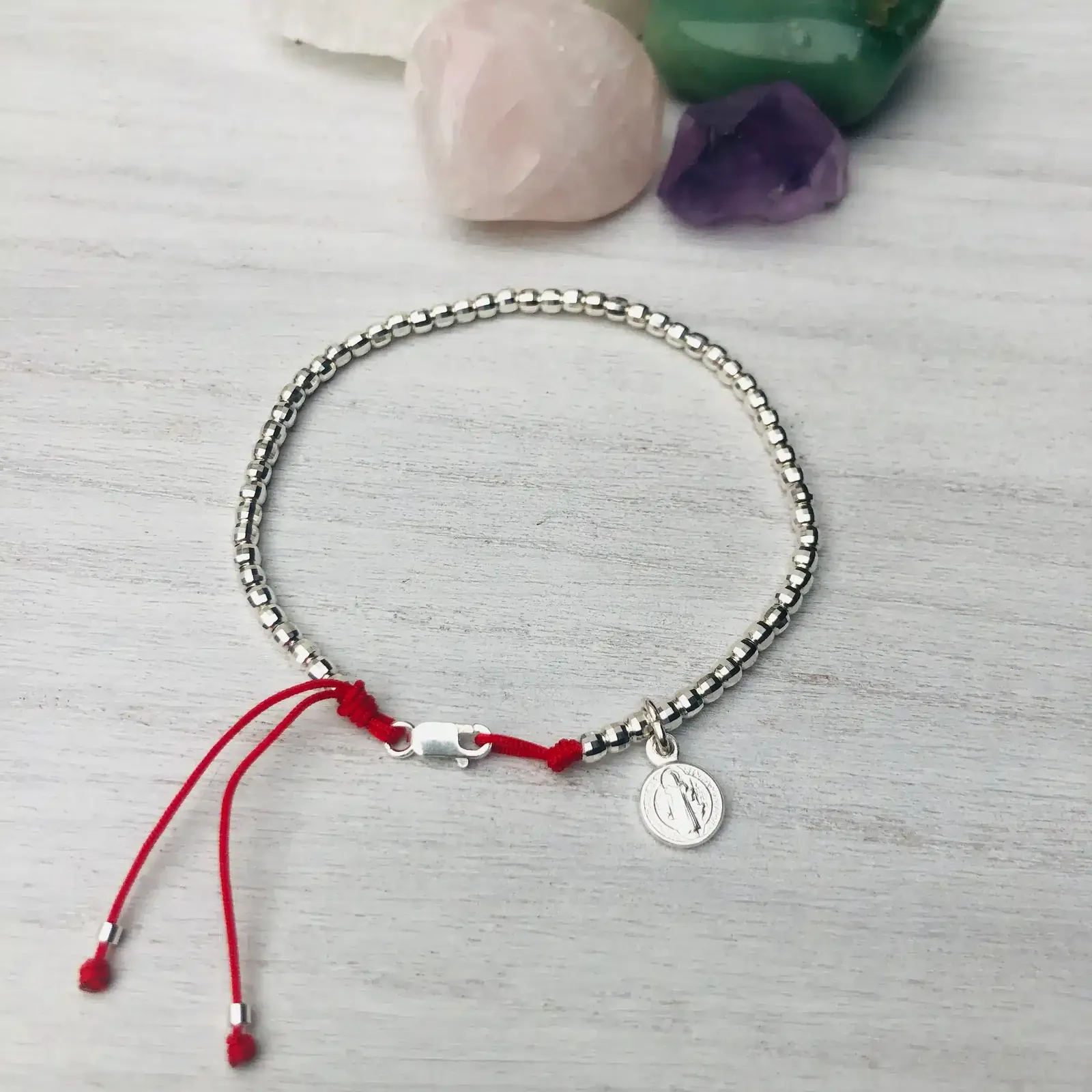 Pulsera de plata 925 en hilo rojo ajustable con dije de San Benito.